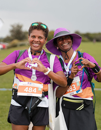 Two Walk for Kids with Cancer participants wearing their medals and looking stoked to have finished the walk