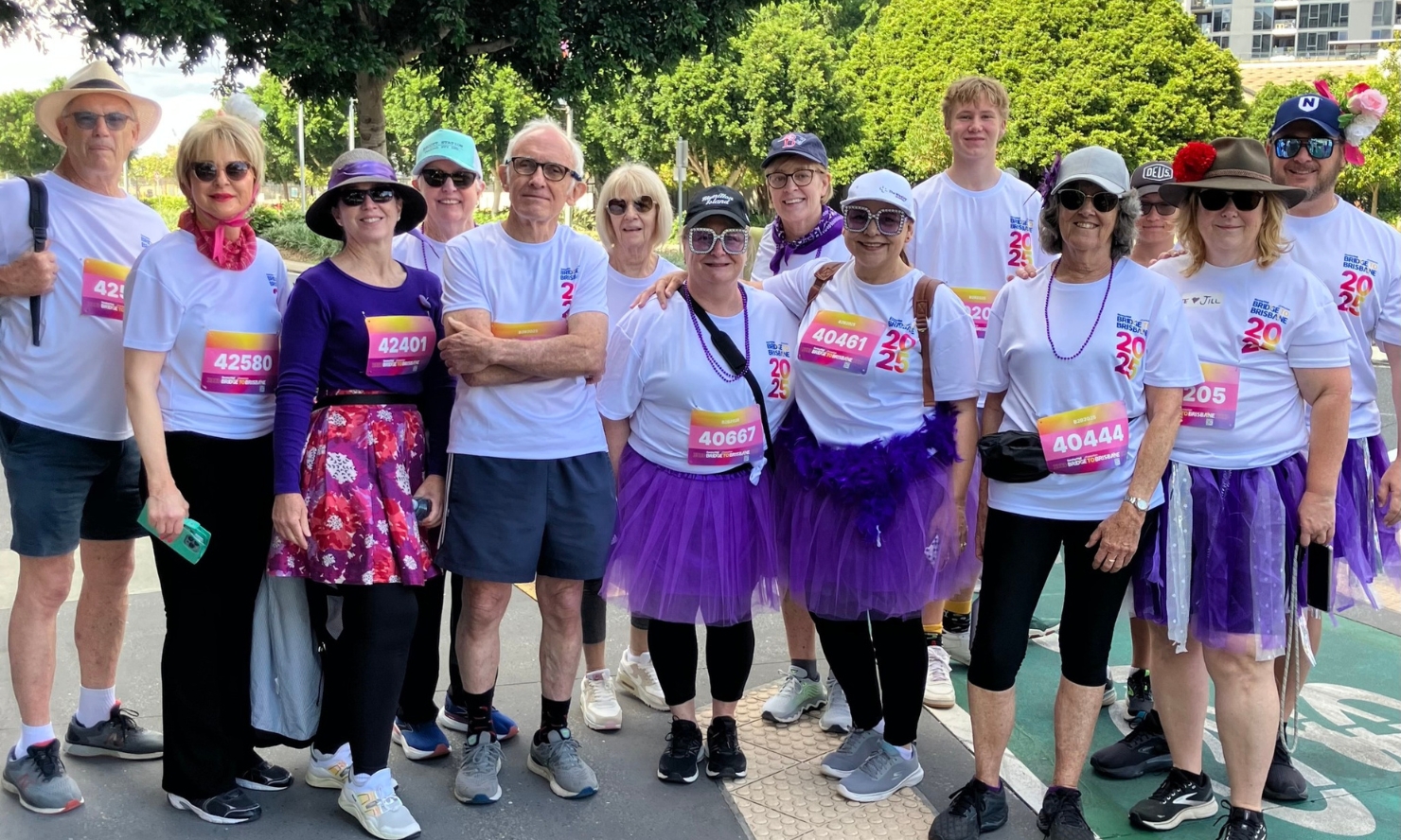 A group of Choices team members in Bridge to Brisbane shirts, purple tutus and other purple bits and bobs pose for a photo.