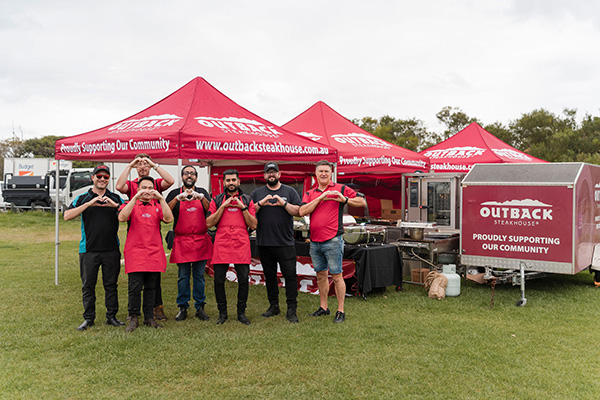 Outback Steakhouse tents and staff set up at the finish line for Walk for Kids with Cancer