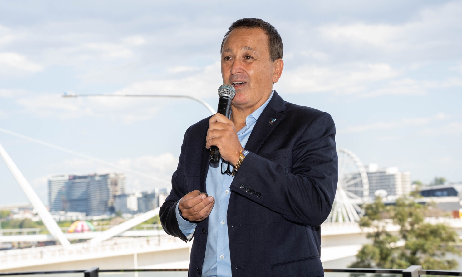 John Gambaro is speaking into a microphone at this years Gambaros Luncheon