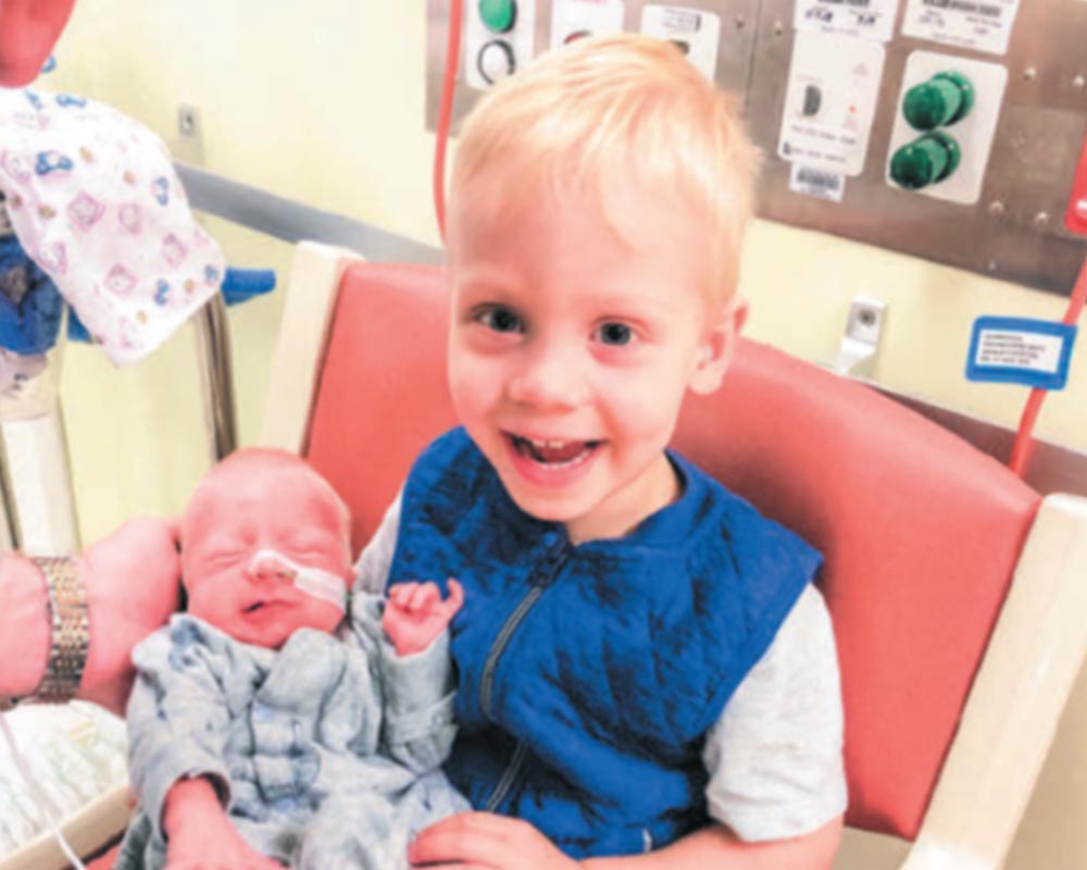 A photo of Sacha holding baby Shiloh gently in a hospital chair A photo of Sacha holding baby Shiloh gently in a hospital chair